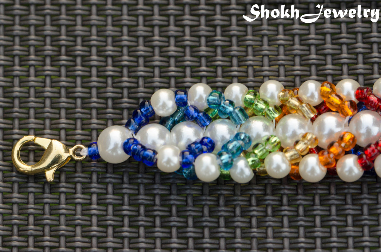 Rainbow seed bead and pearl woven bracelet with clasp.