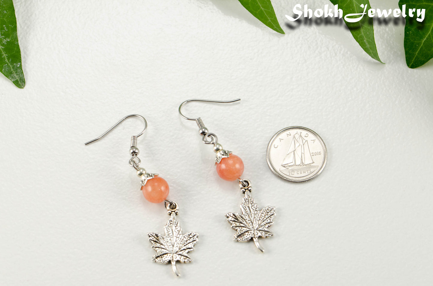 Orange Quartzite and Tibetan Silver Maple Leaf Dangle Earrings beside a dime.