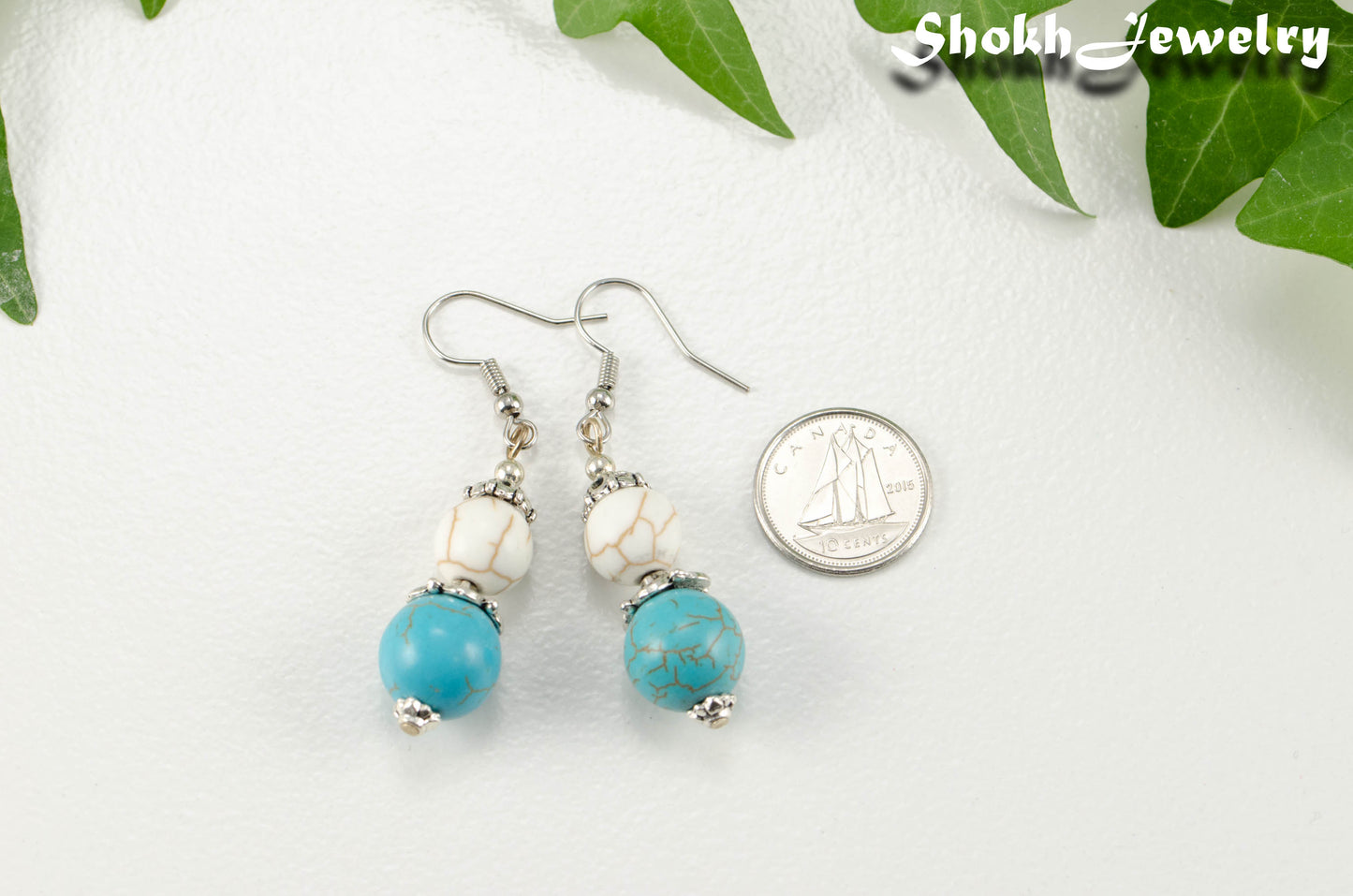 Turquoise and White Howlite Dangle Earrings beside a dime.