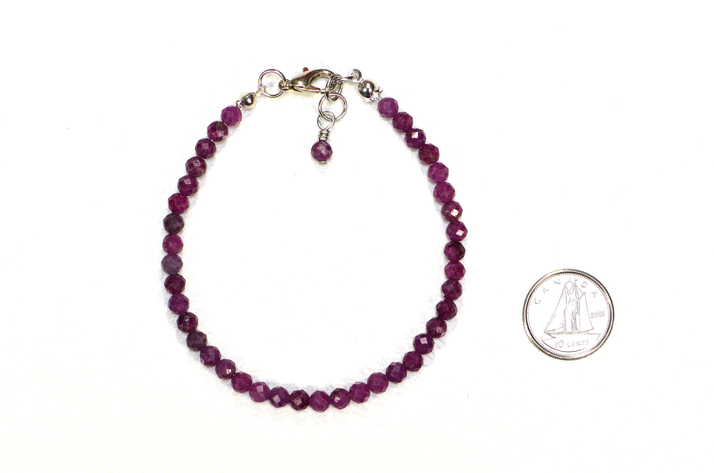 4mm Faceted Ruby Anklet beside a dime.