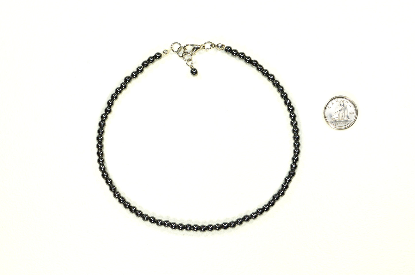 4mm Natural Hematite Choker Necklace beside a dime.