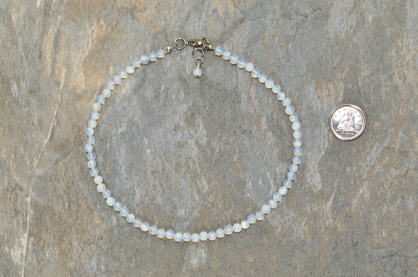 4mm Opal Crystal Choker Necklace beside a dime.