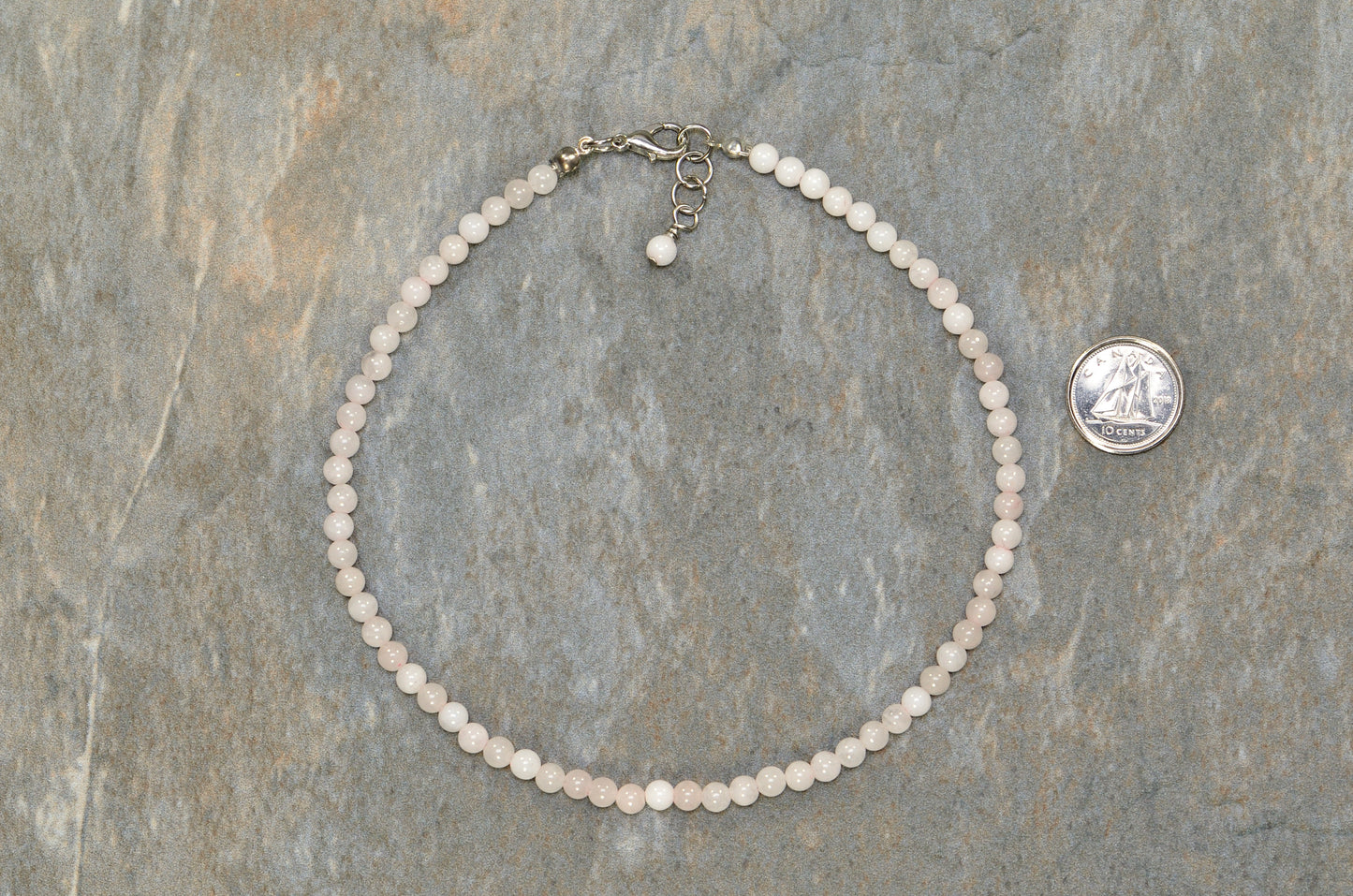 4mm Rose Quartz Crystal Choker Necklace beside a dime.