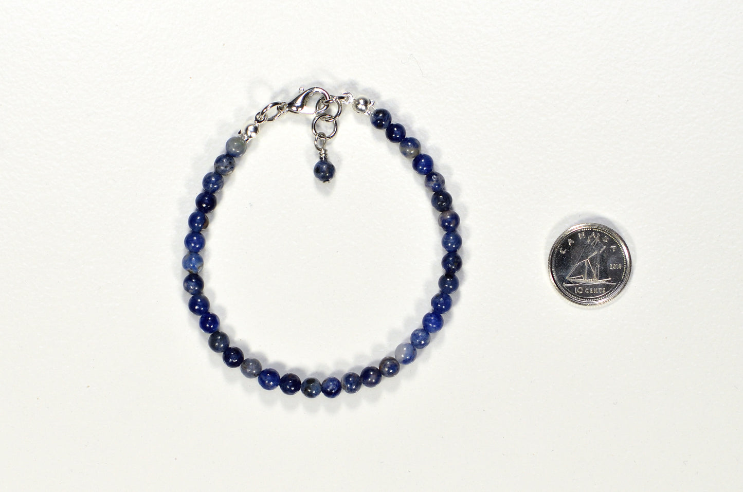 4mm Sodalite Bracelet with Clasp beside a dime.