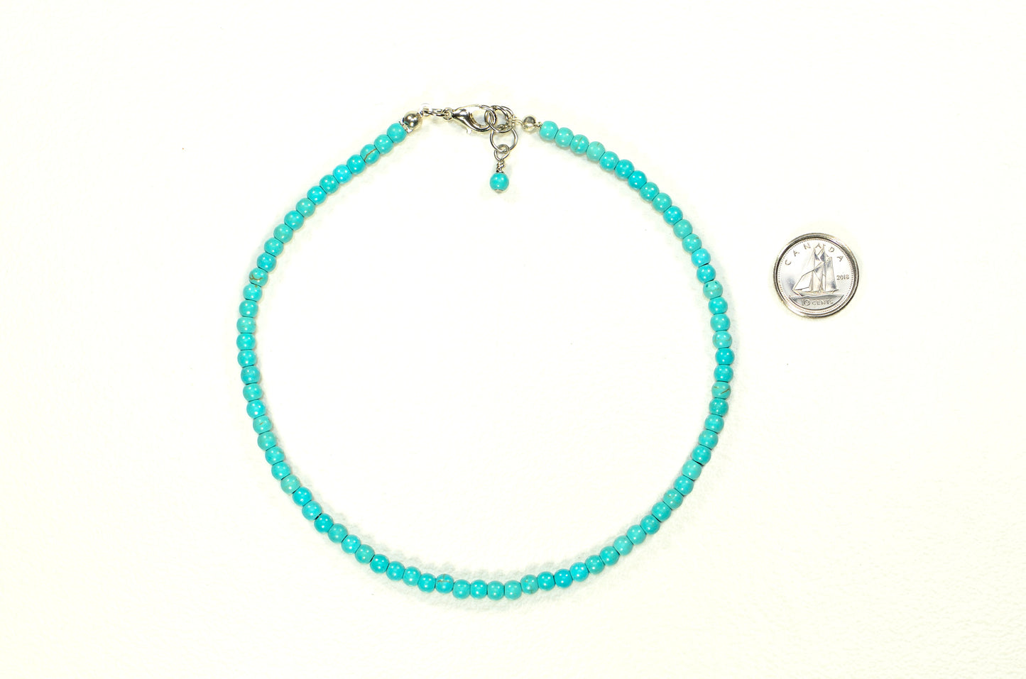 4mm Turquoise Howlite Choker Necklace beside a dime.