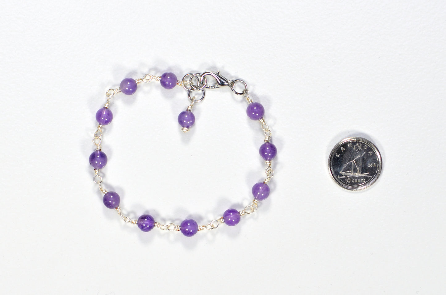 Handmade 6mm Amethyst Link Bracelet beside a dime.