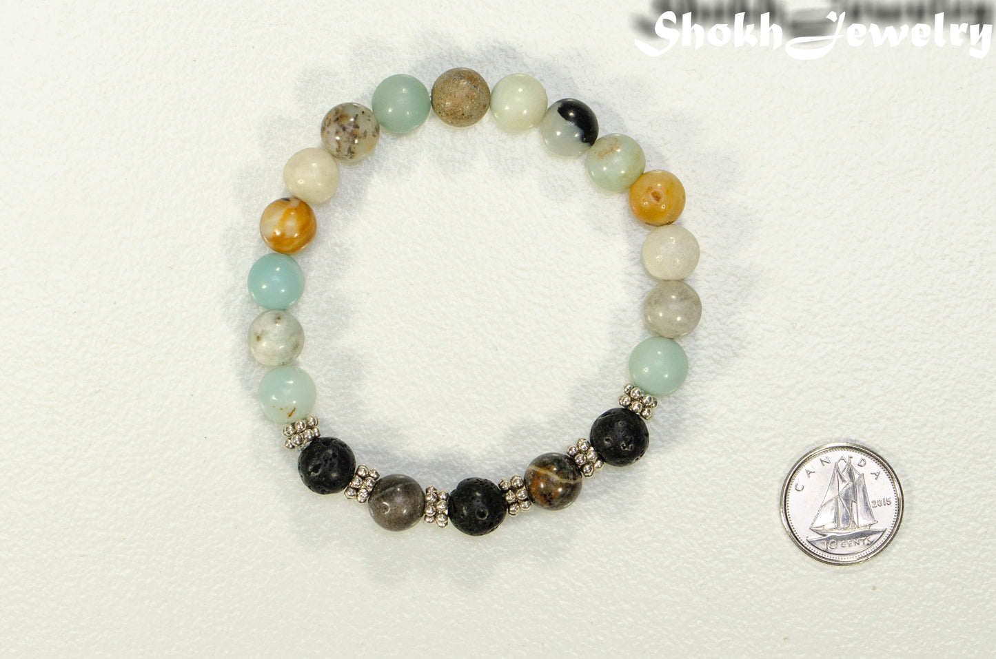 8mm Amazonite and Black Lava Stone Bracelet beside a dime.