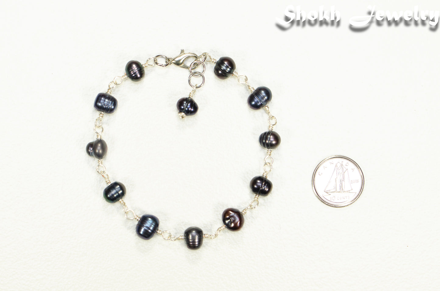 Black Dyed Freshwater Pearls Link Chain Bracelet beside a dime.