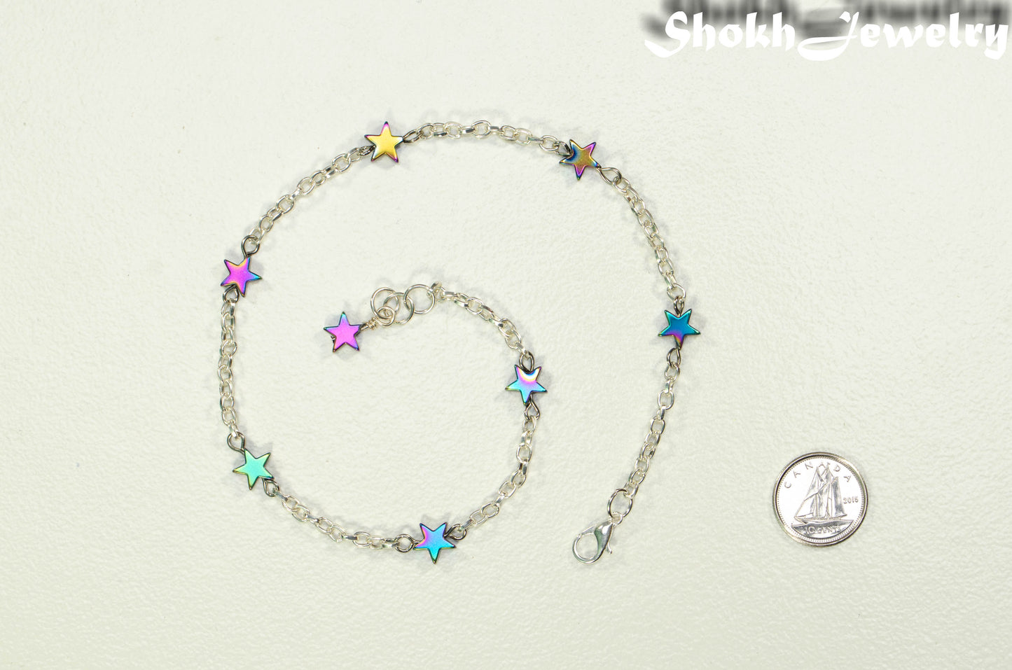 Rainbow Hematite Star and Chain Choker Necklace beside a dime.