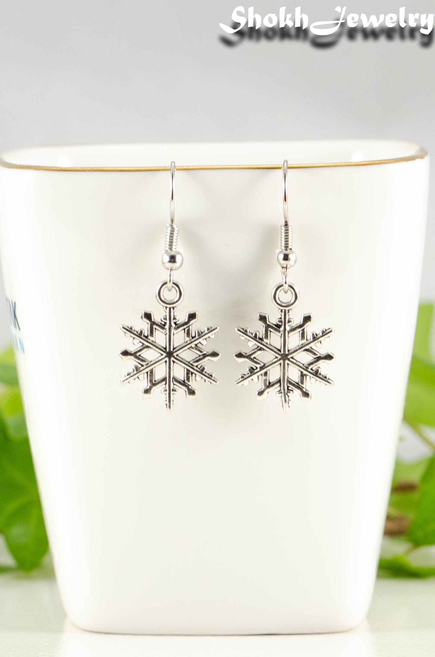 Close up of Christmas Snowflakes Charm Earrings.