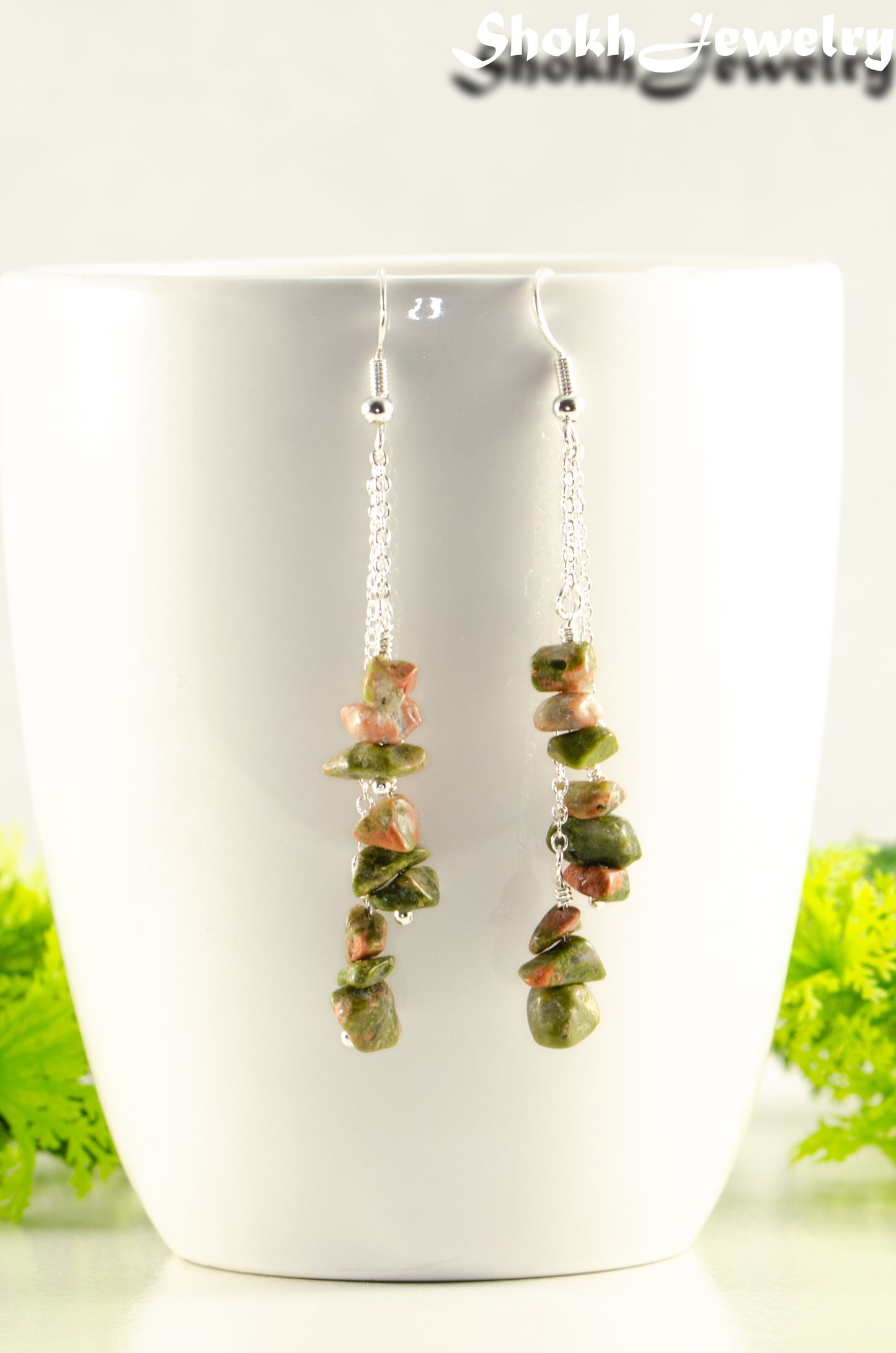 Long Silver Plated Chain and Unakite Crystal Chip Earrings displayed on a coffee mug.