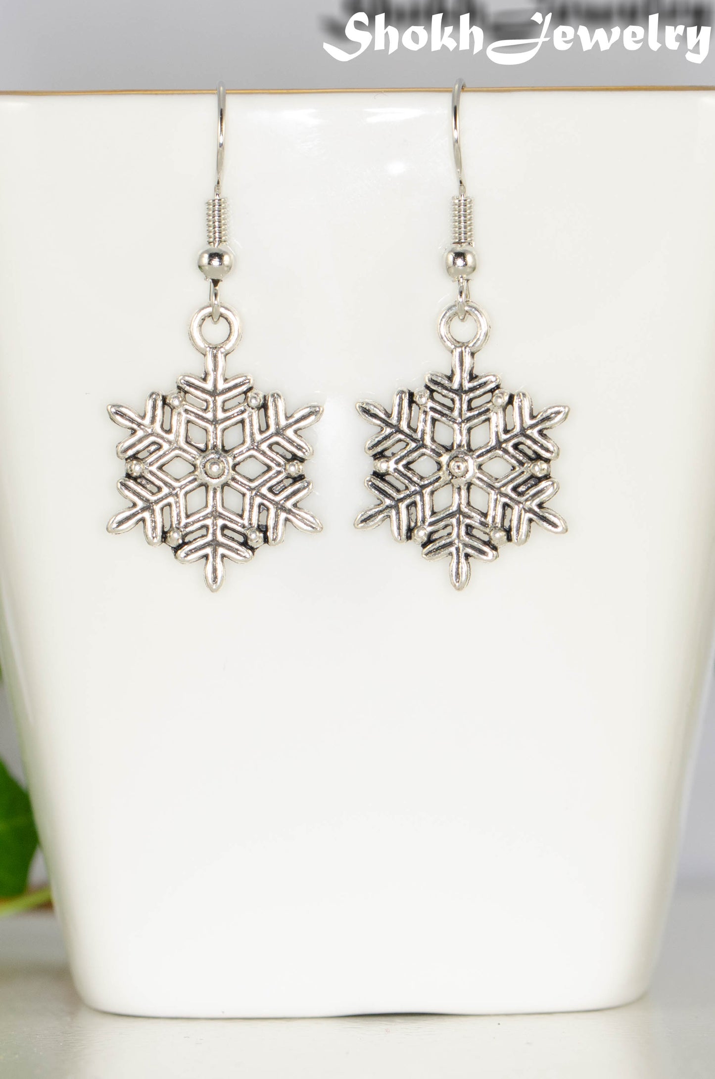 Close up of Christmas Snowflakes Charm Earrings.