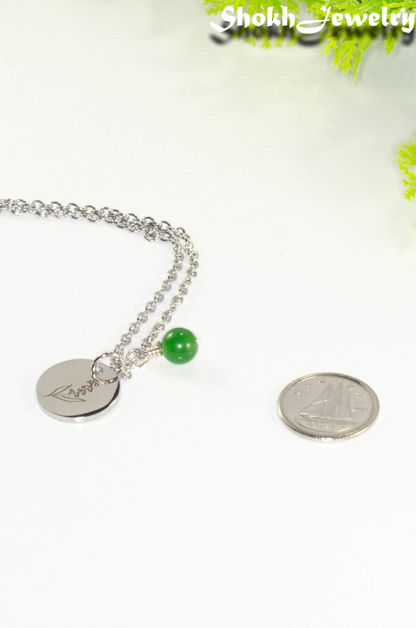 Close up of May Birth Flower Necklace with Emerald Birthstone Pendant.