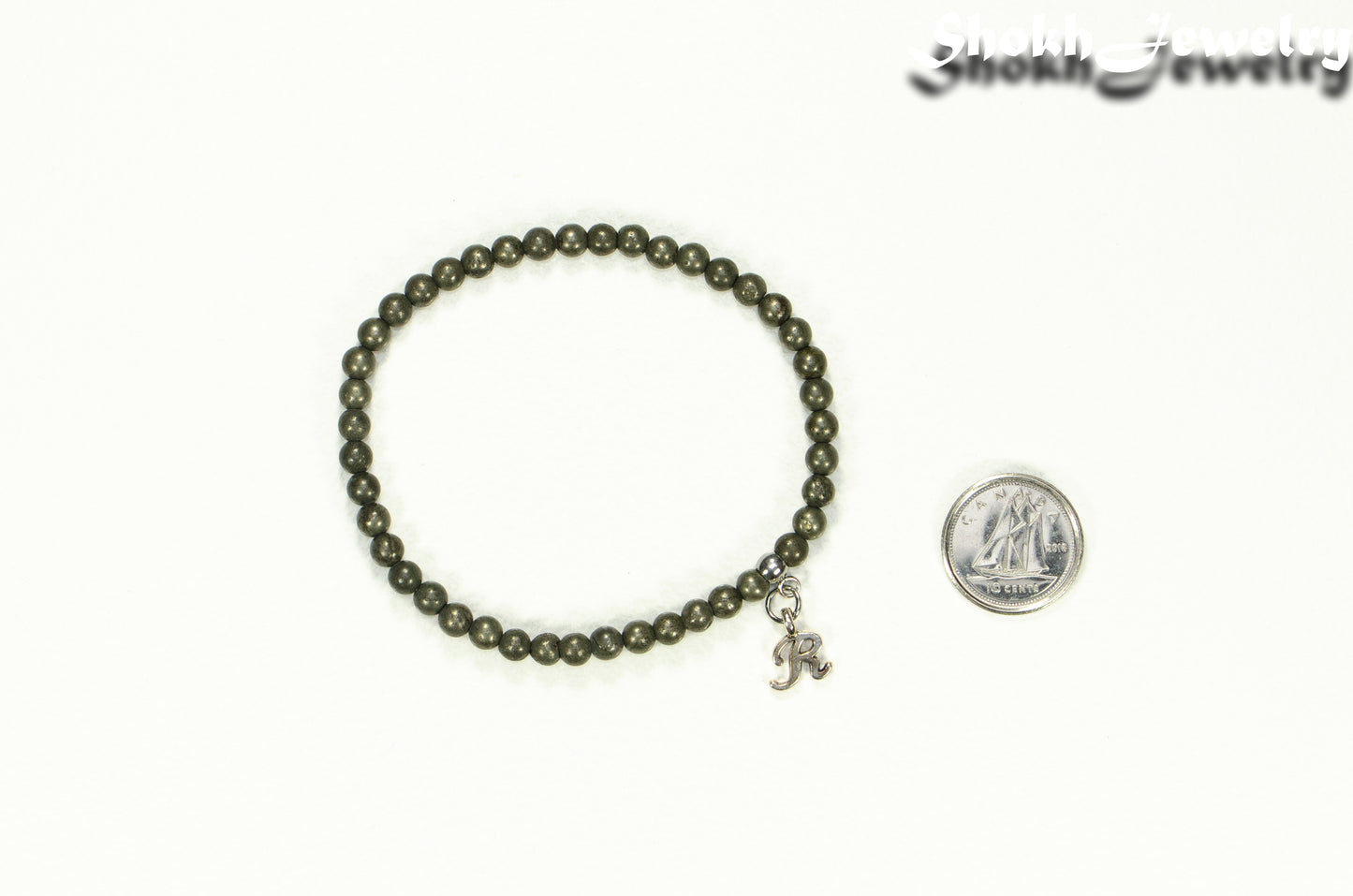 4mm Natural Pyrite Bracelet with Initial beside a dime.