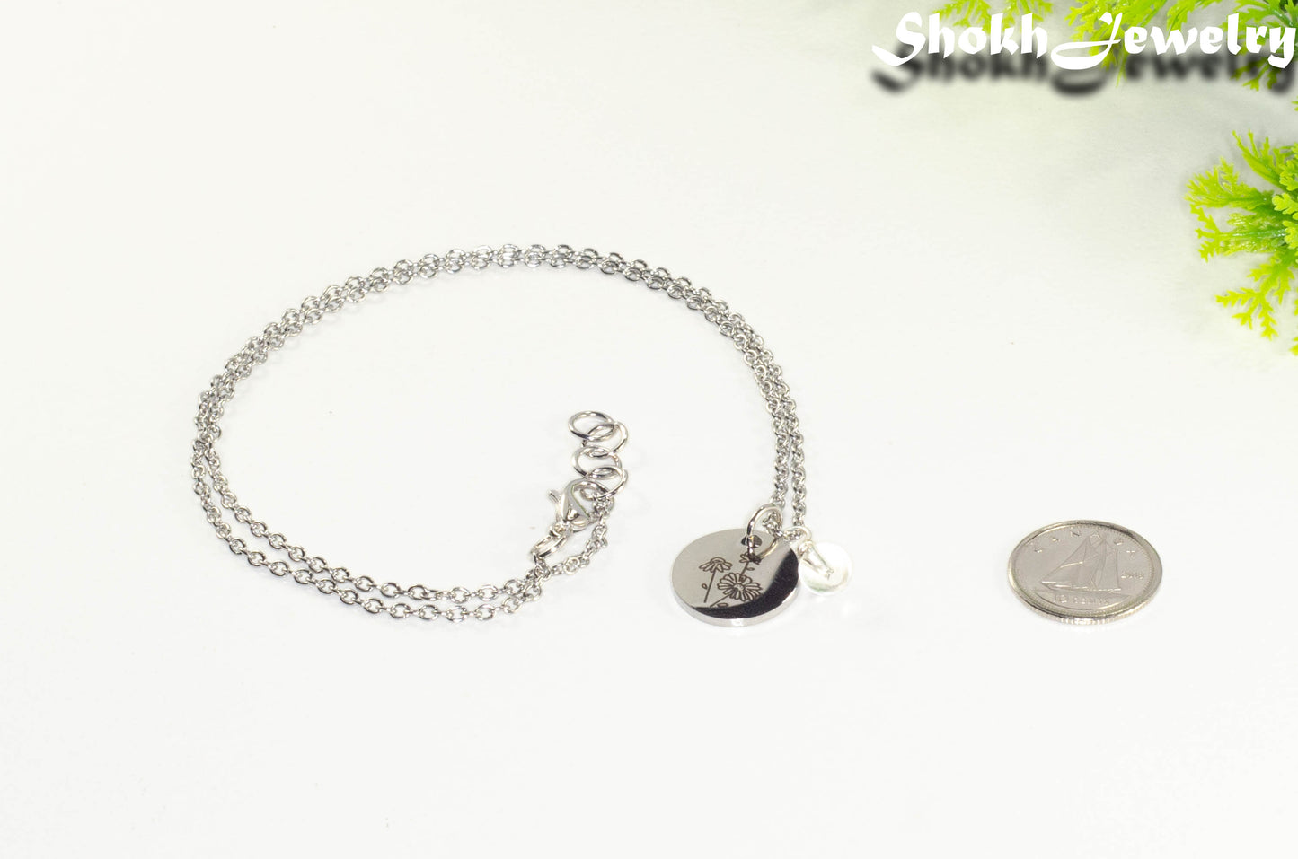 April Birth Flower Necklace with Clear Quartz Birthstone Pendant beside a dime.