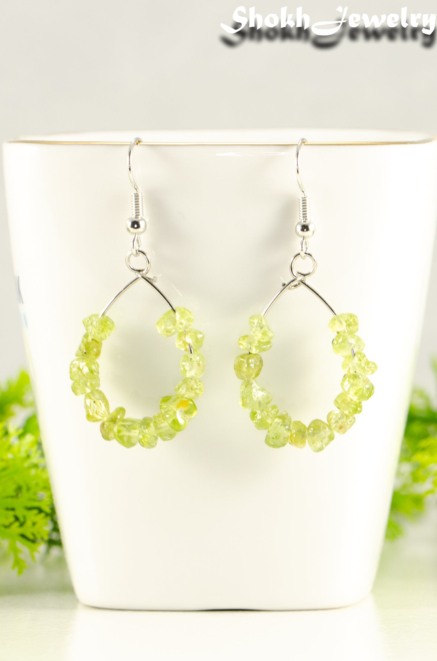 Close up of Natural Peridot Crystal Chip Hoop Earrings.