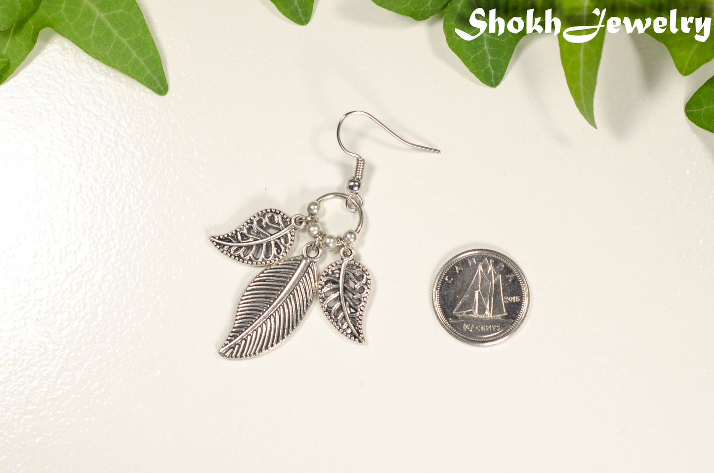 Statement Tibetan Silver Leaf Charm Earring beside a dime.