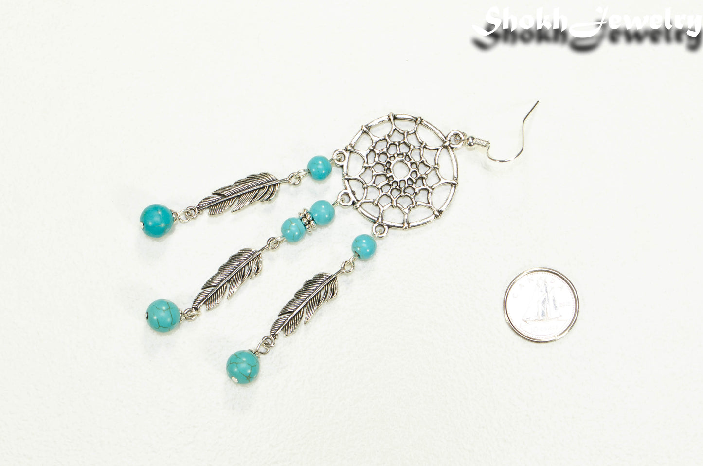 Extra Long Turquoise Howlite Dream Catcher Earring beside a dime.