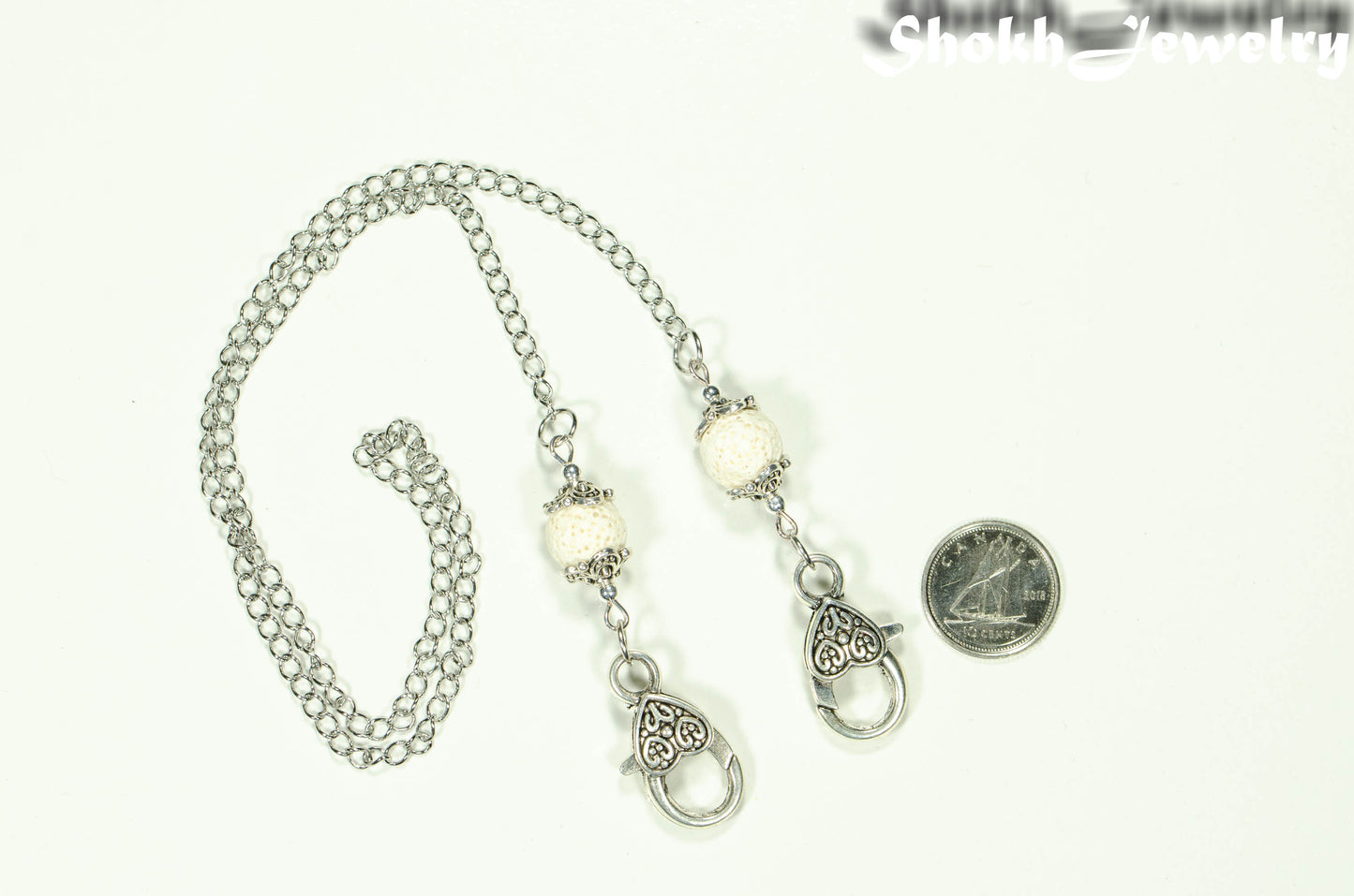 White Lava Stone Eyeglass chain/Face Mask Lanyard beside a dime.