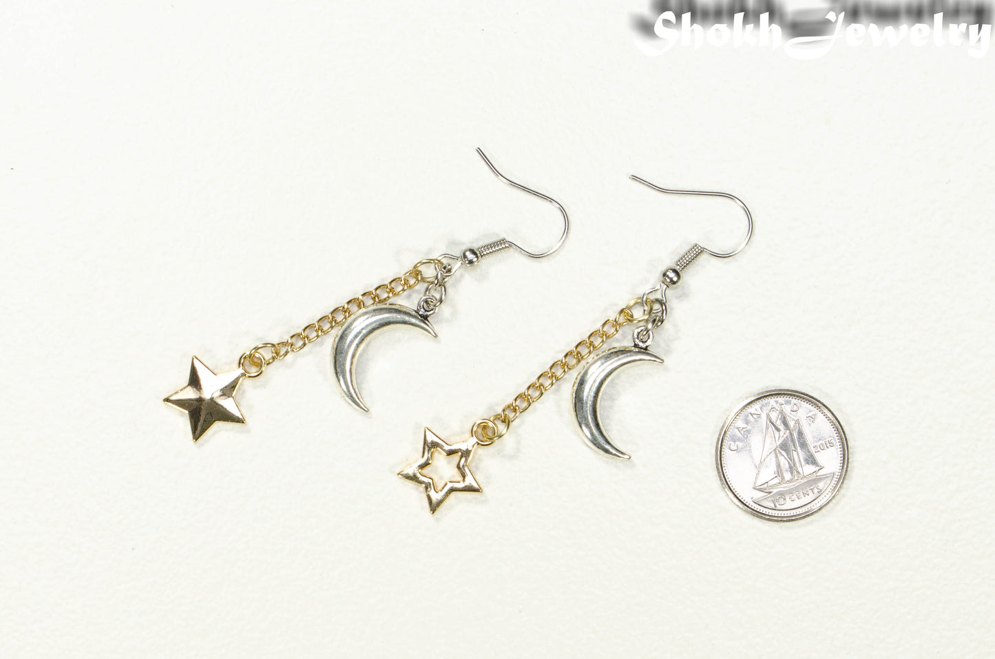 Crescent Moon and Mismatched Gold Star Earrings beside a dime.