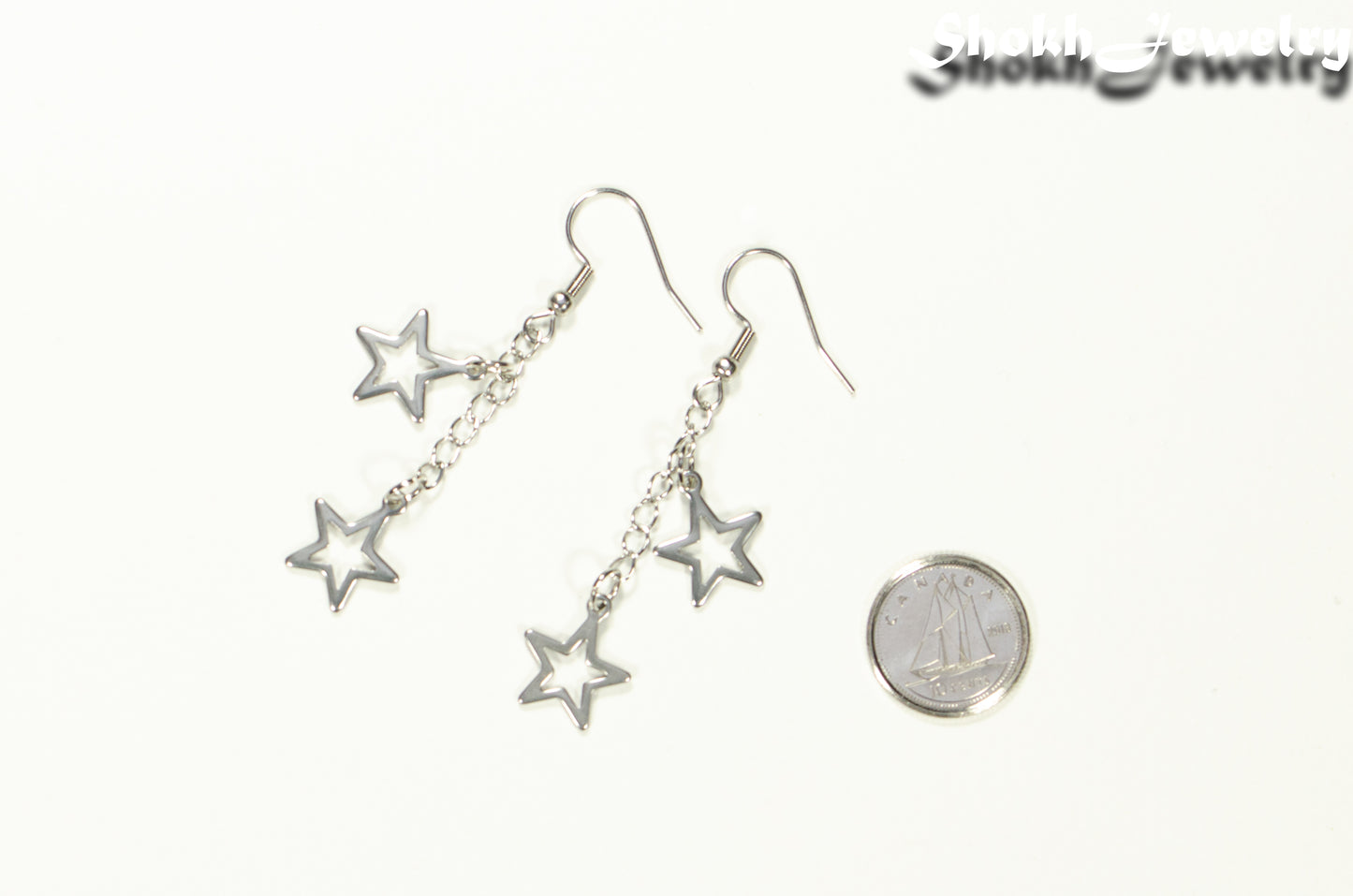Stainless steel chain and 2 star earrings beside a dime.