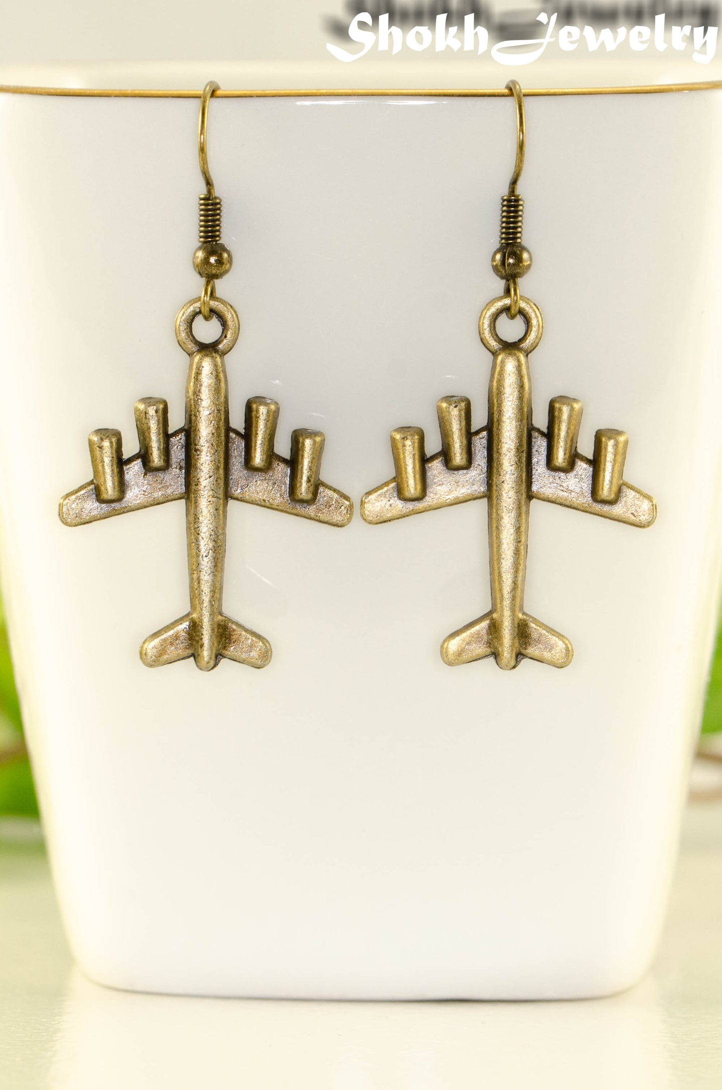 Close up of Antique Bronze 3D Plane Charm Earrings.