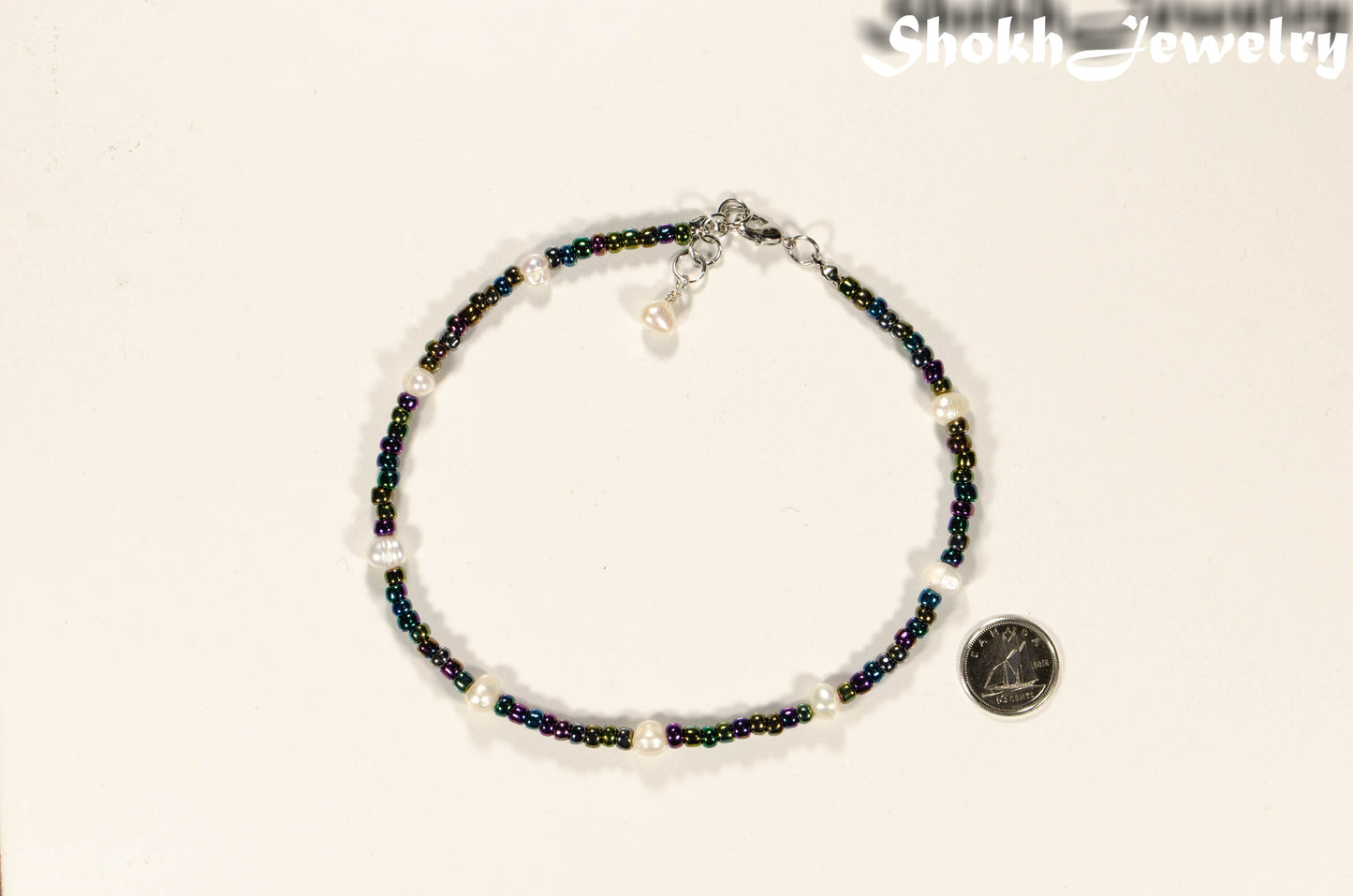 Freshwater Pearl and Black Seed Bead Anklet beaside a dime.