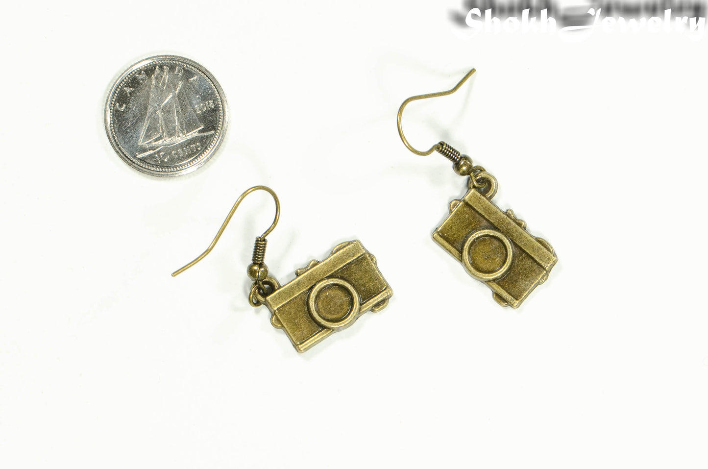 Antique Bronze Camera Charm Earrings beside a dime.