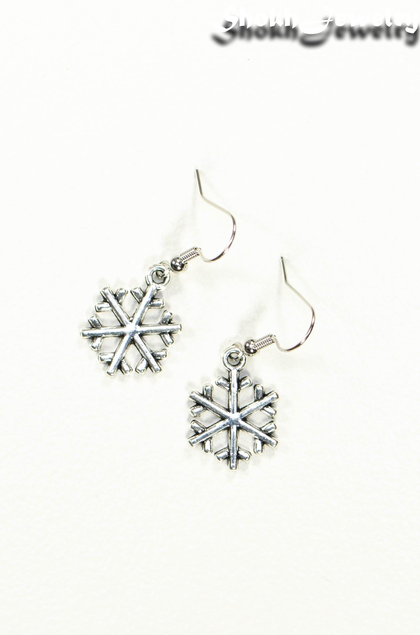 Top view of Christmas Snowflakes Charm Earrings.