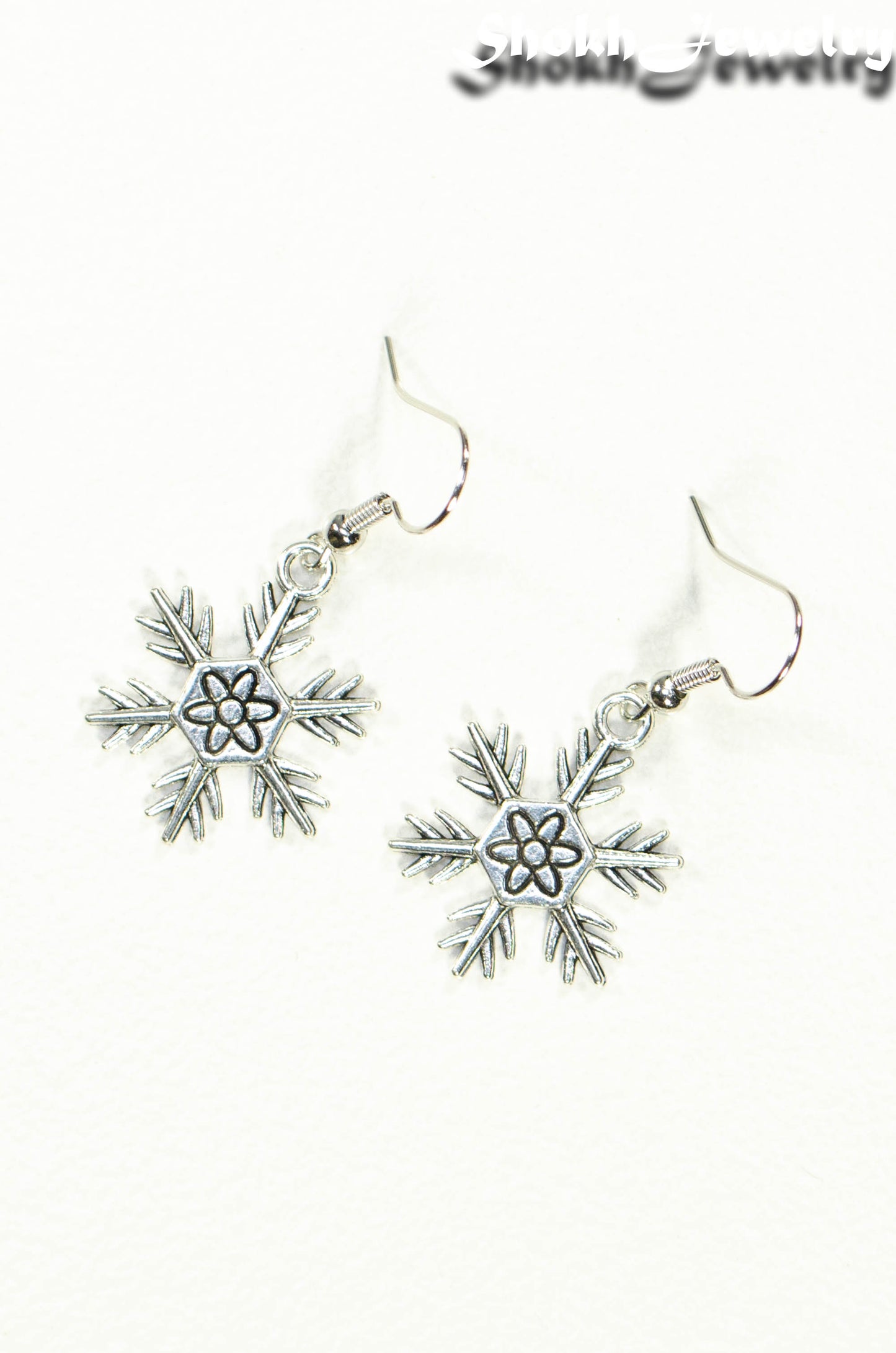 Top view of Christmas Snowflakes Charm Earrings.