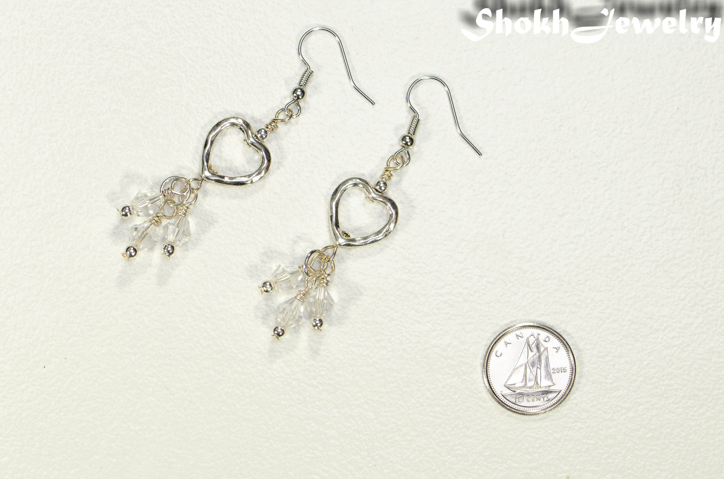 Silver Plated Heart and Clear Glass Crystal Cluster Earrings beside a dime.