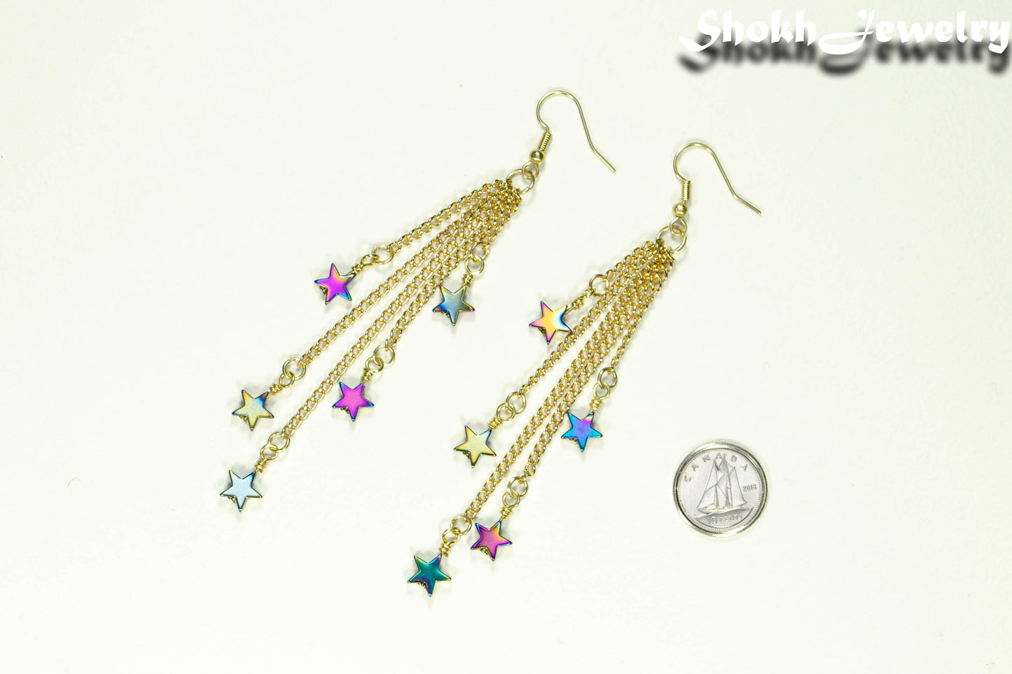Extra Long Rainbow Hematite Star Earrings beside a dime.