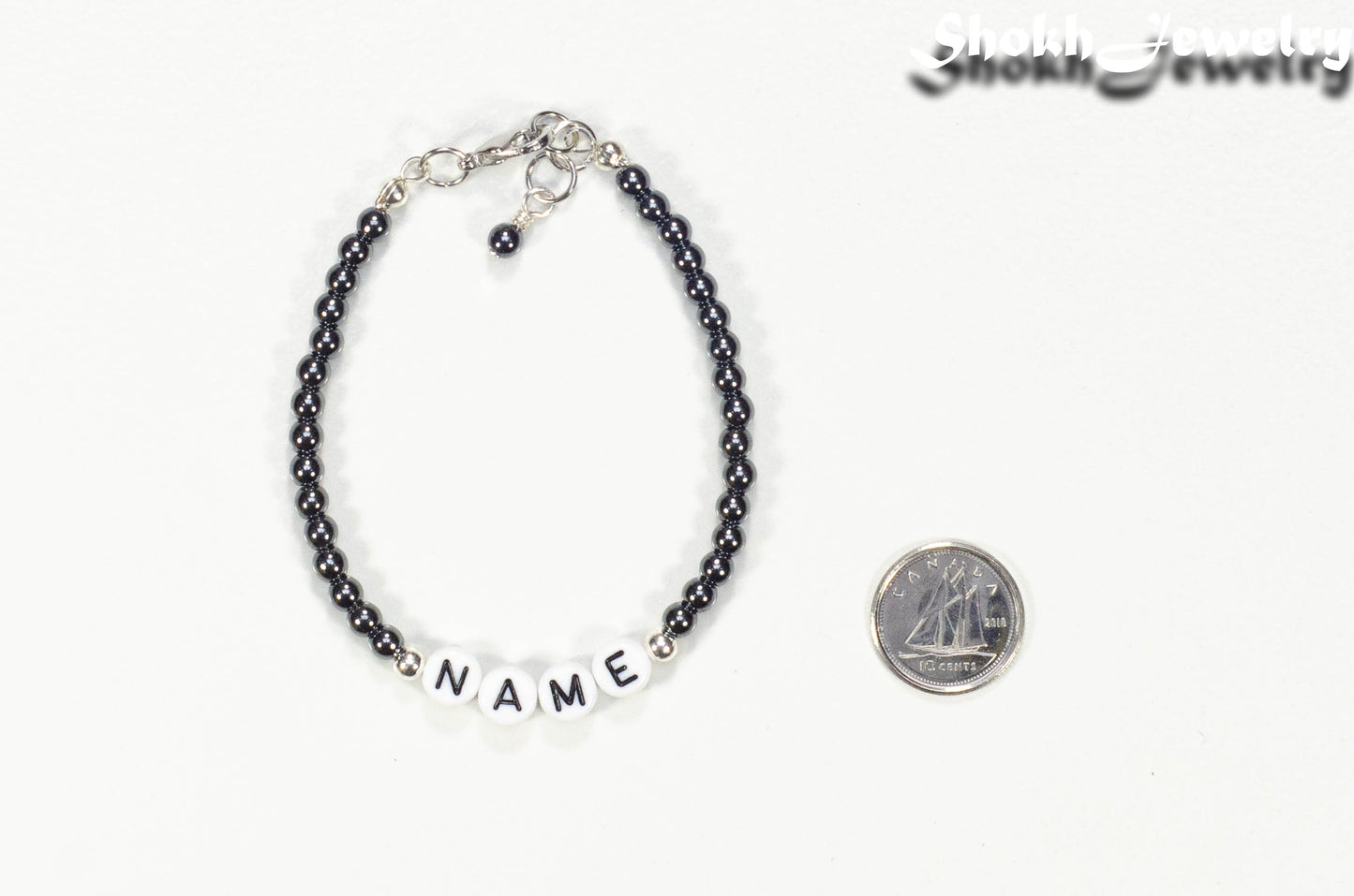 Personalized Hematite Stone Name Bracelet with Clasp beside a dime.