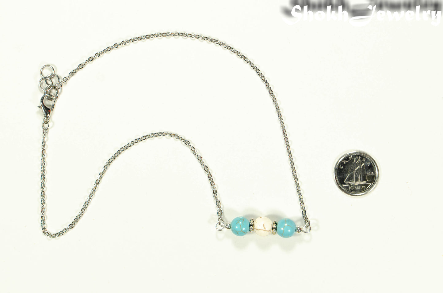 Turquoise and White Howlite and Dainty Chain Choker Necklace beside a dime.
