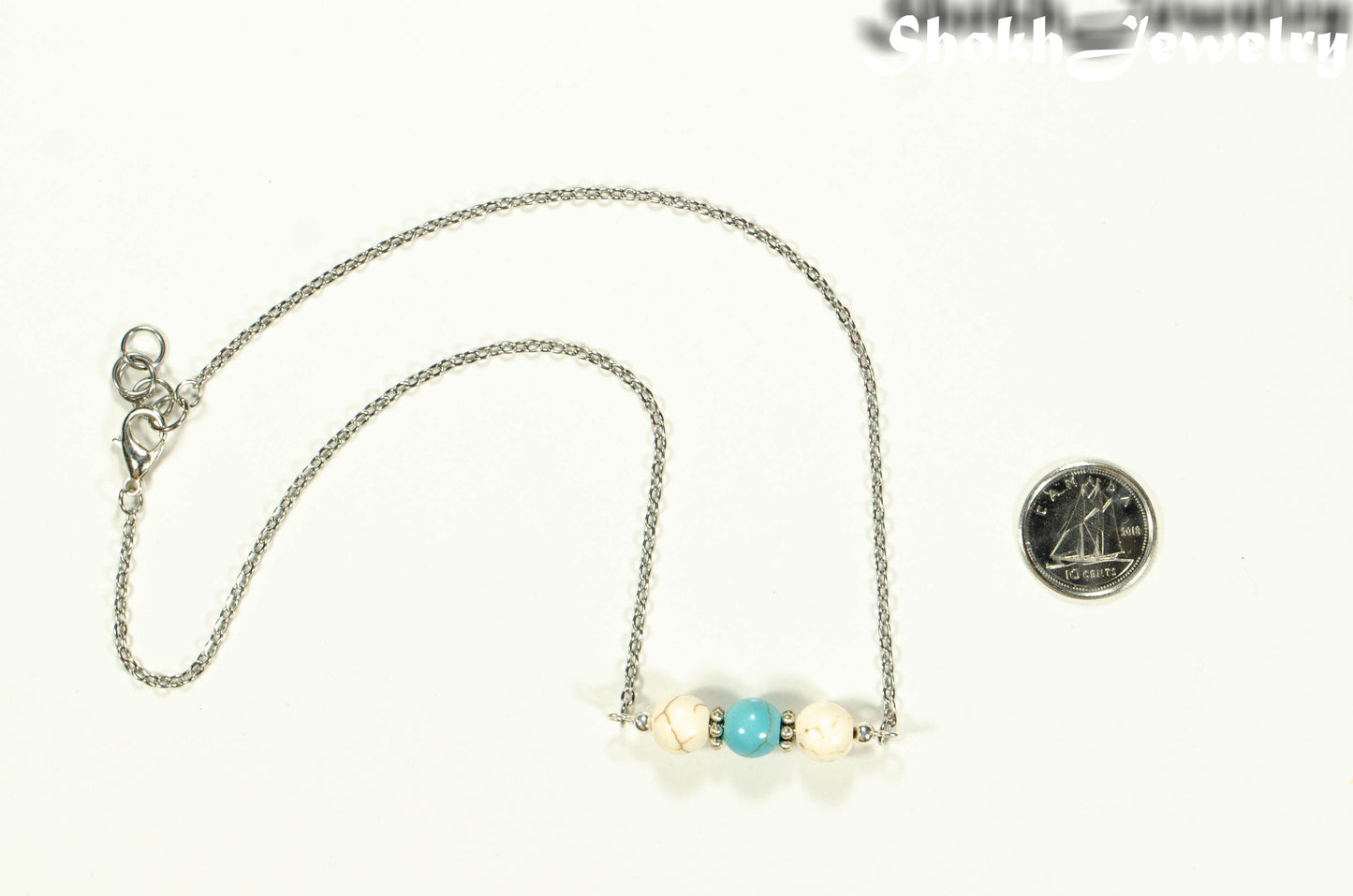 White and Turquoise Howlite and Dainty Chain Choker Necklace beside a dime.