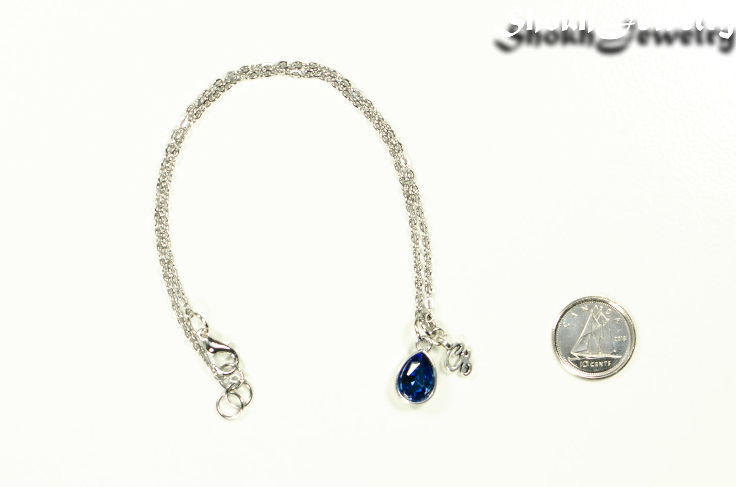 Small Personalized September Birthstone Choker Necklace beside a dime.