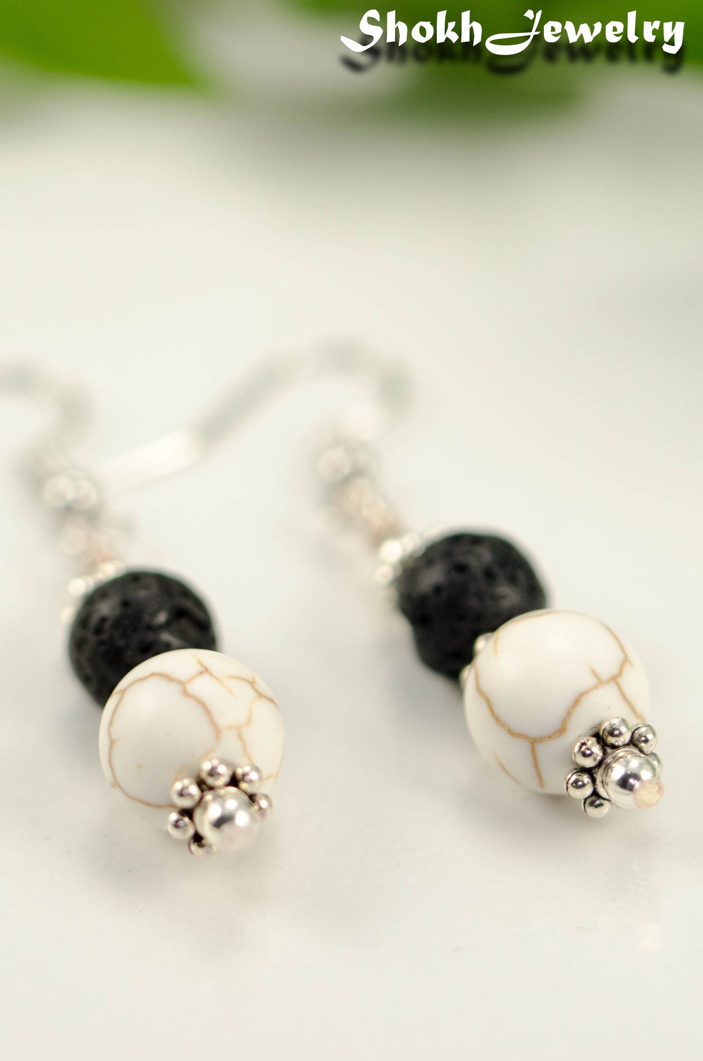 Close up of White Howlite and Black Lava Rock Earrings