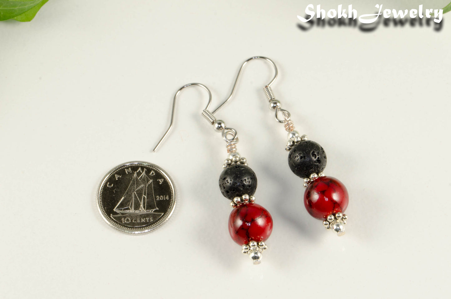 Red Quartzite and Black Lava Rock Earrings beside a dime.