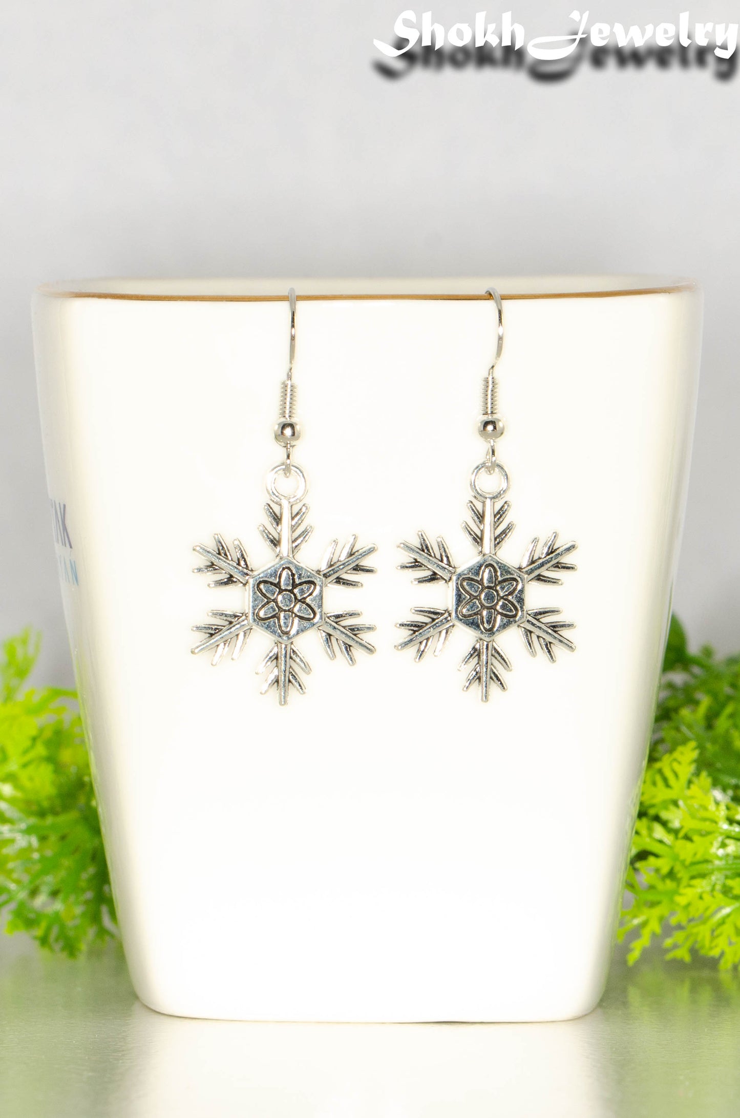 Close up of Christmas Snowflakes Charm Earrings.