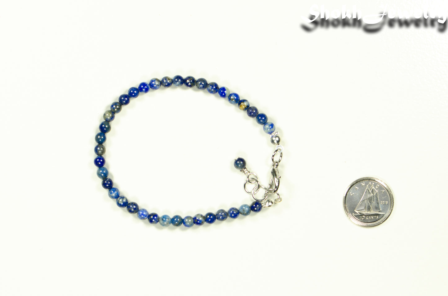 4mm Lapis Lazuli Bracelet with Clasp beside a dime.