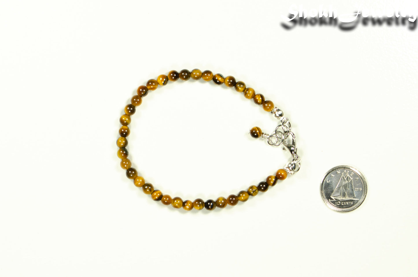 4mm Tiger's Eye anklet with Clasp beside a dime.
