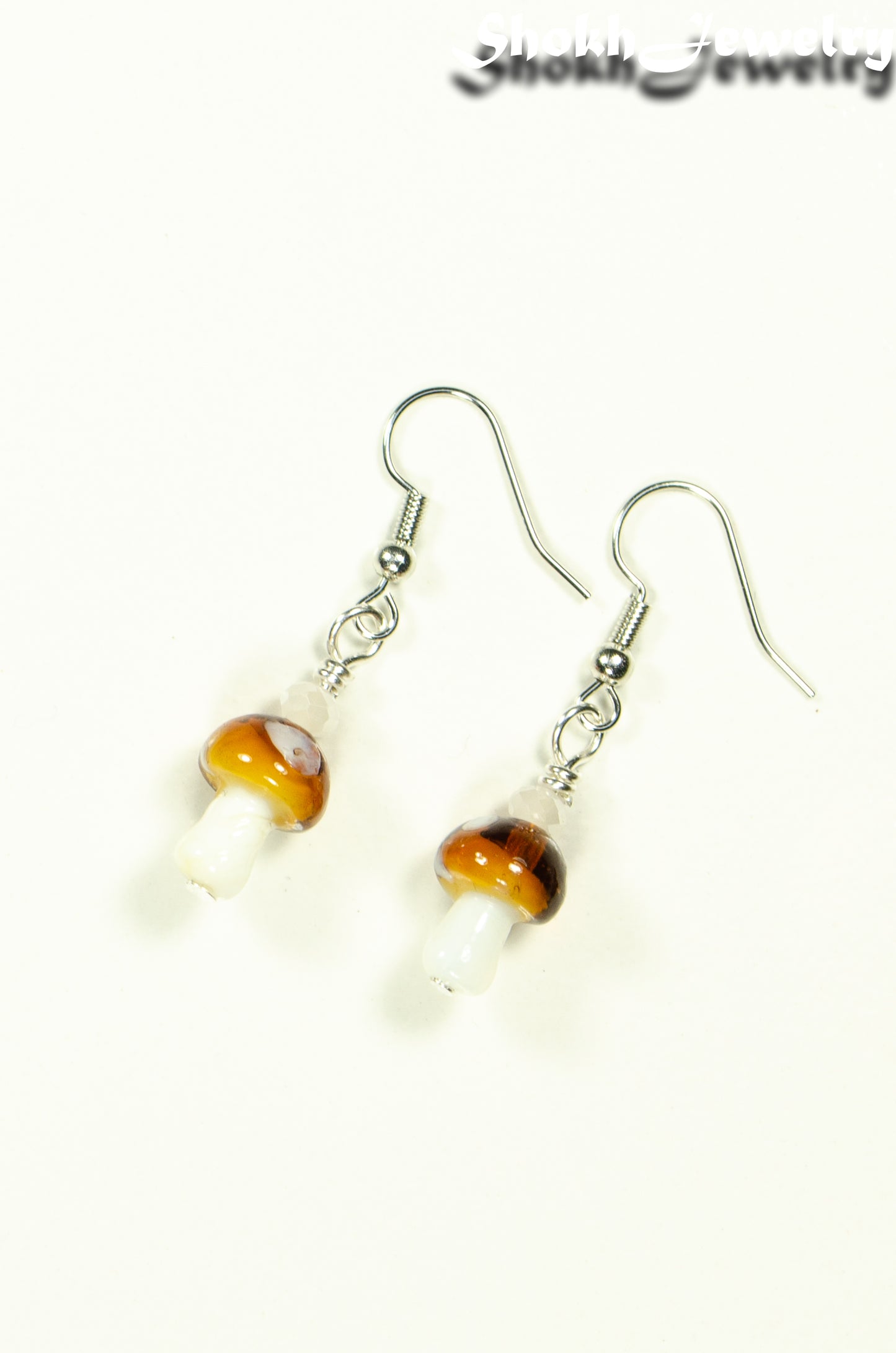 Top view of Tiny Brown Mushroom Glass Bead Earrings.