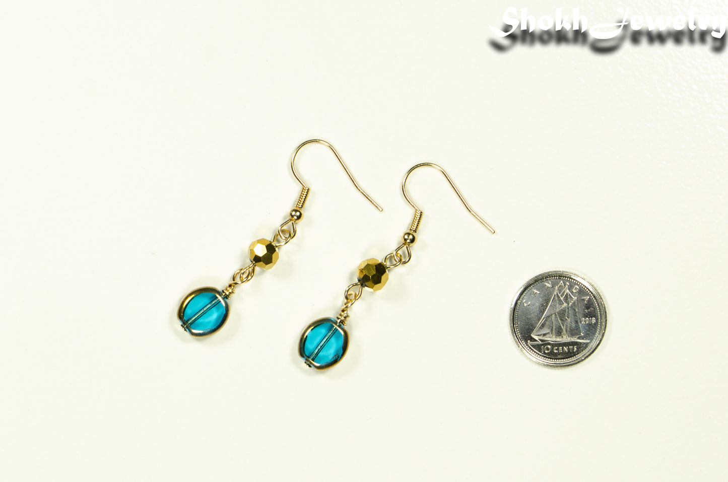 Teal and Gold Glass Bead Earrings beside a dime.