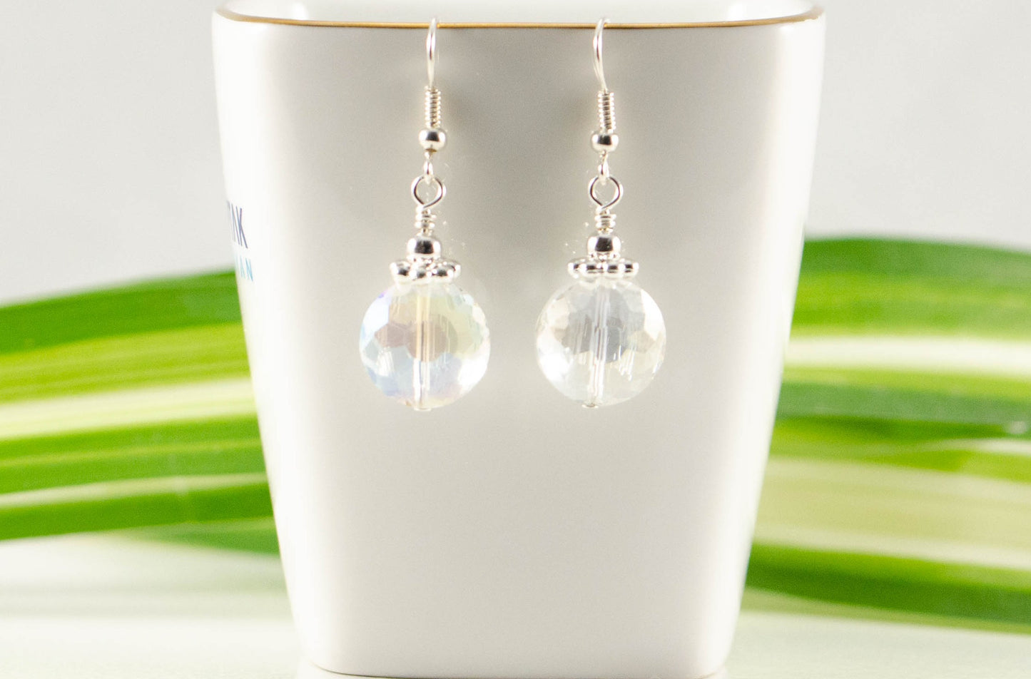 Clear AB Glass Crystal Beads Earrings displayed on a tea cup.