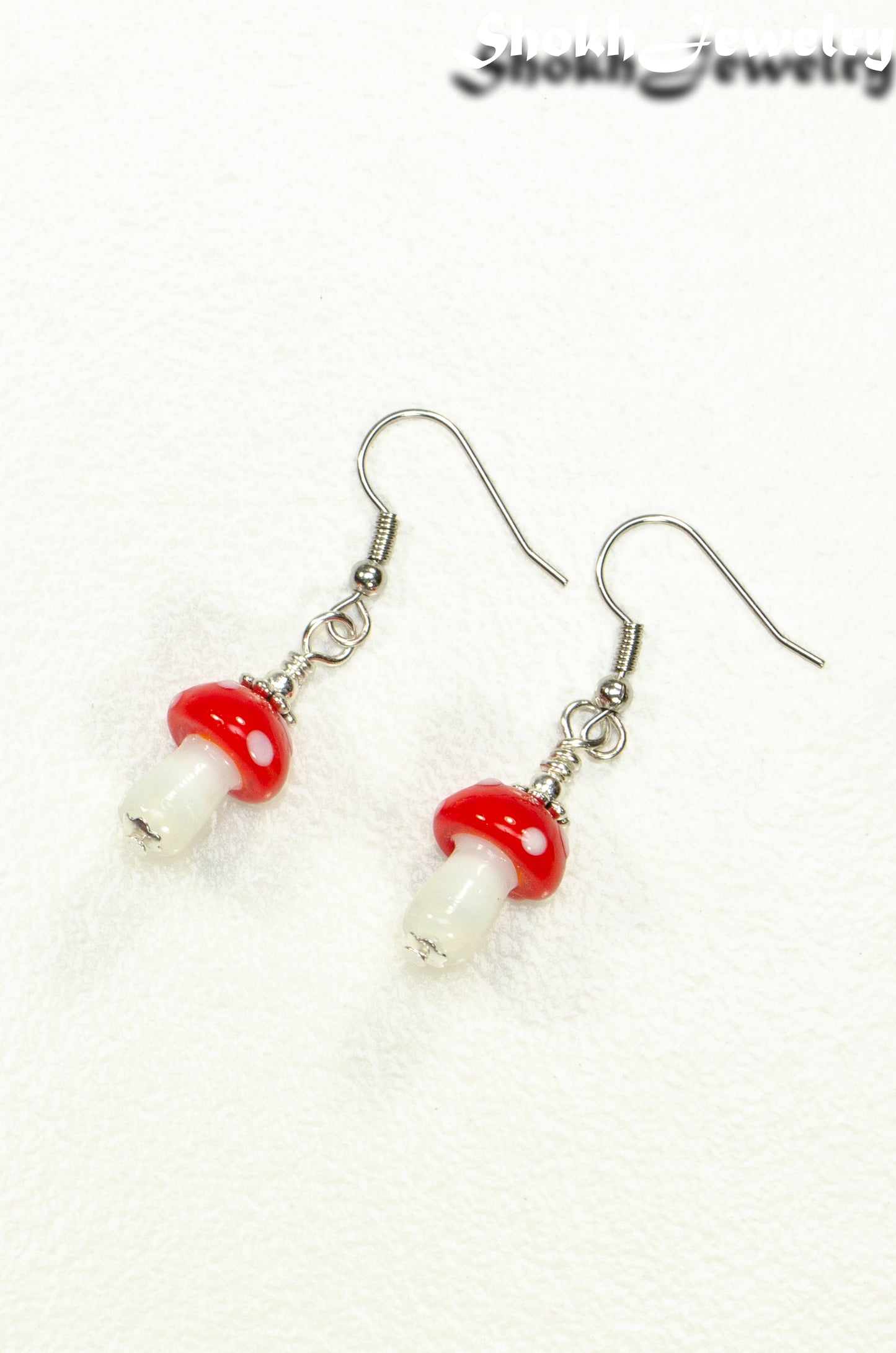 Top view of Tiny Red Mushroom Glass Bead Earrings.