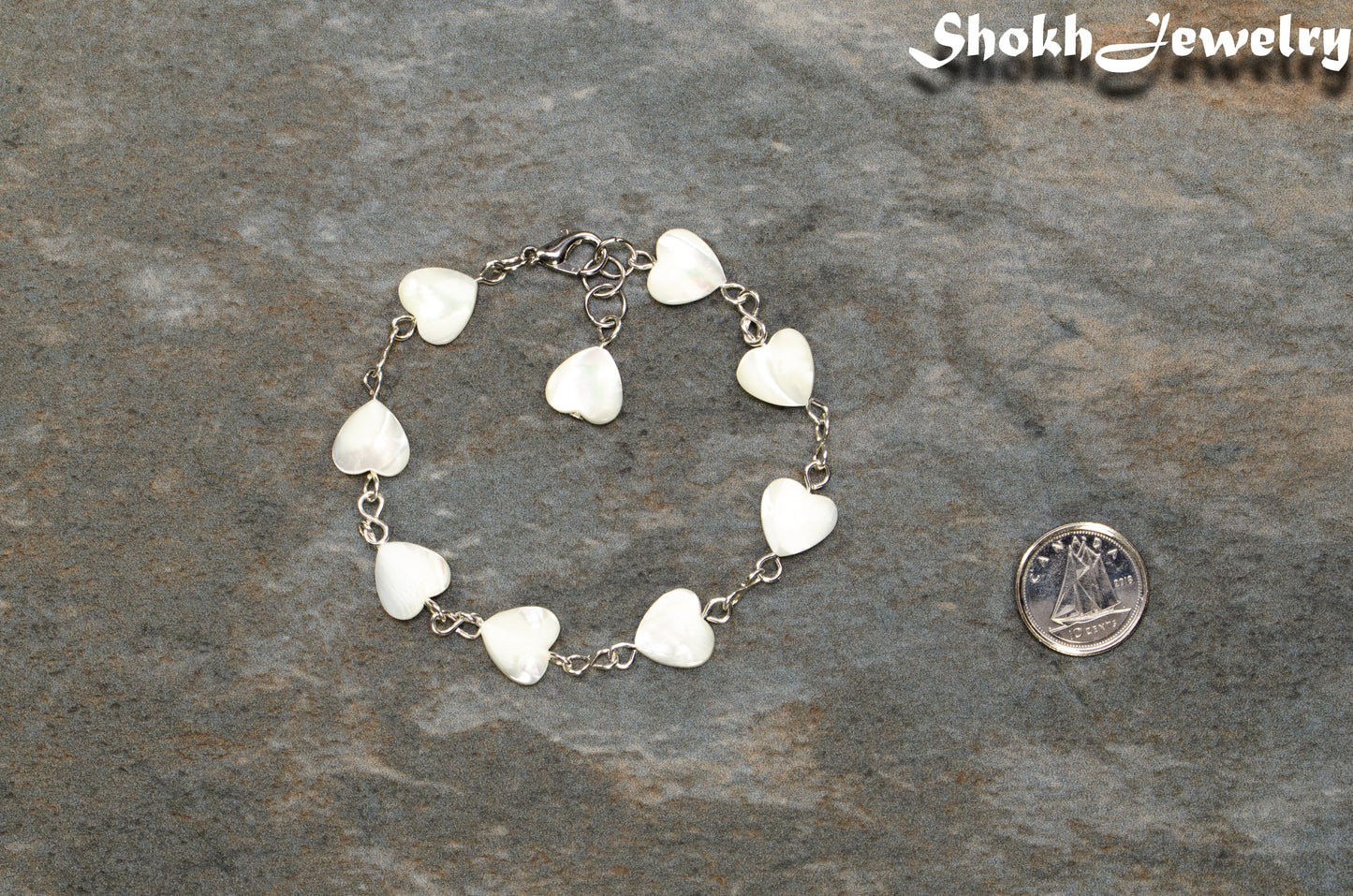 Natural Seashell Heart Link Bracelet beside a dime.