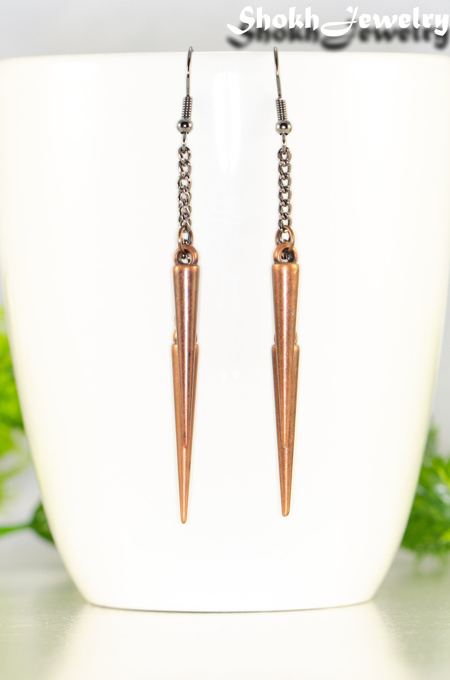 Close up of Long chain and antique copper spike earrings.