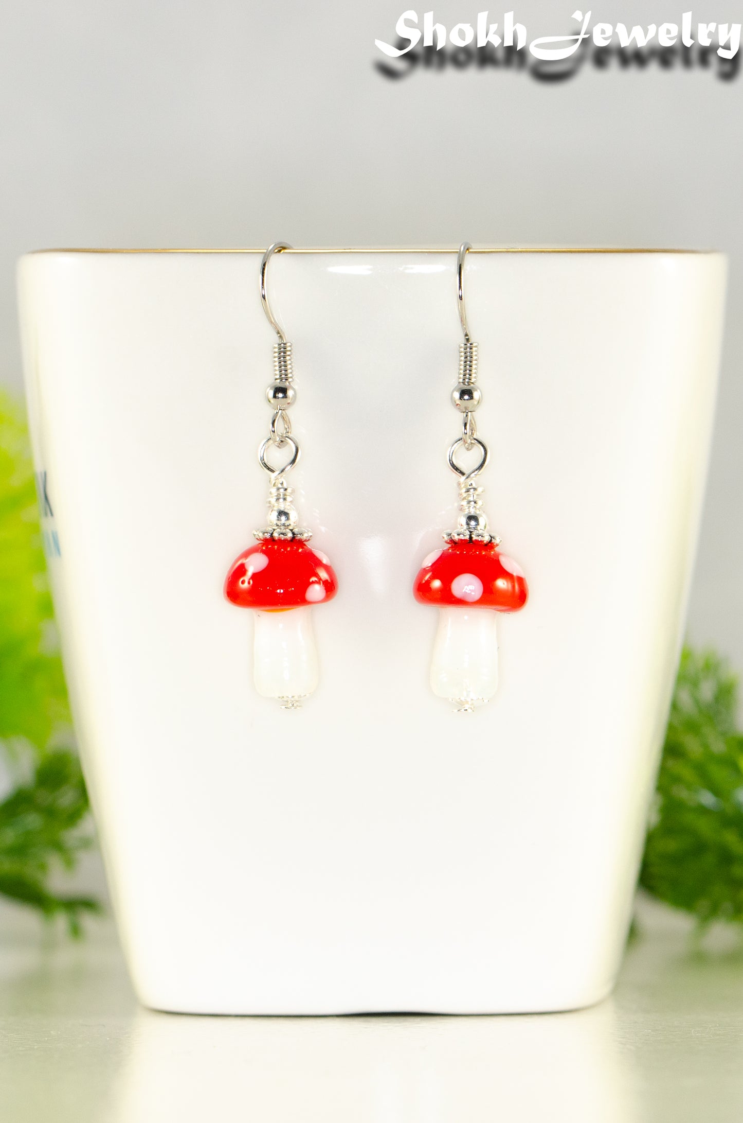 Close up of Tiny Red Mushroom Glass Bead Earrings.