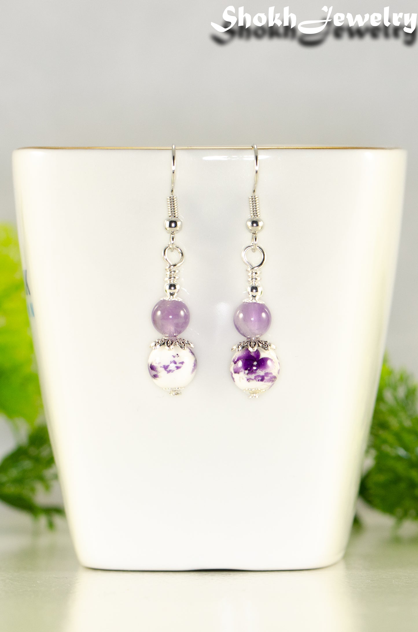 Close up of Small Floral Ceramic Bead and Amethyst Earrings.