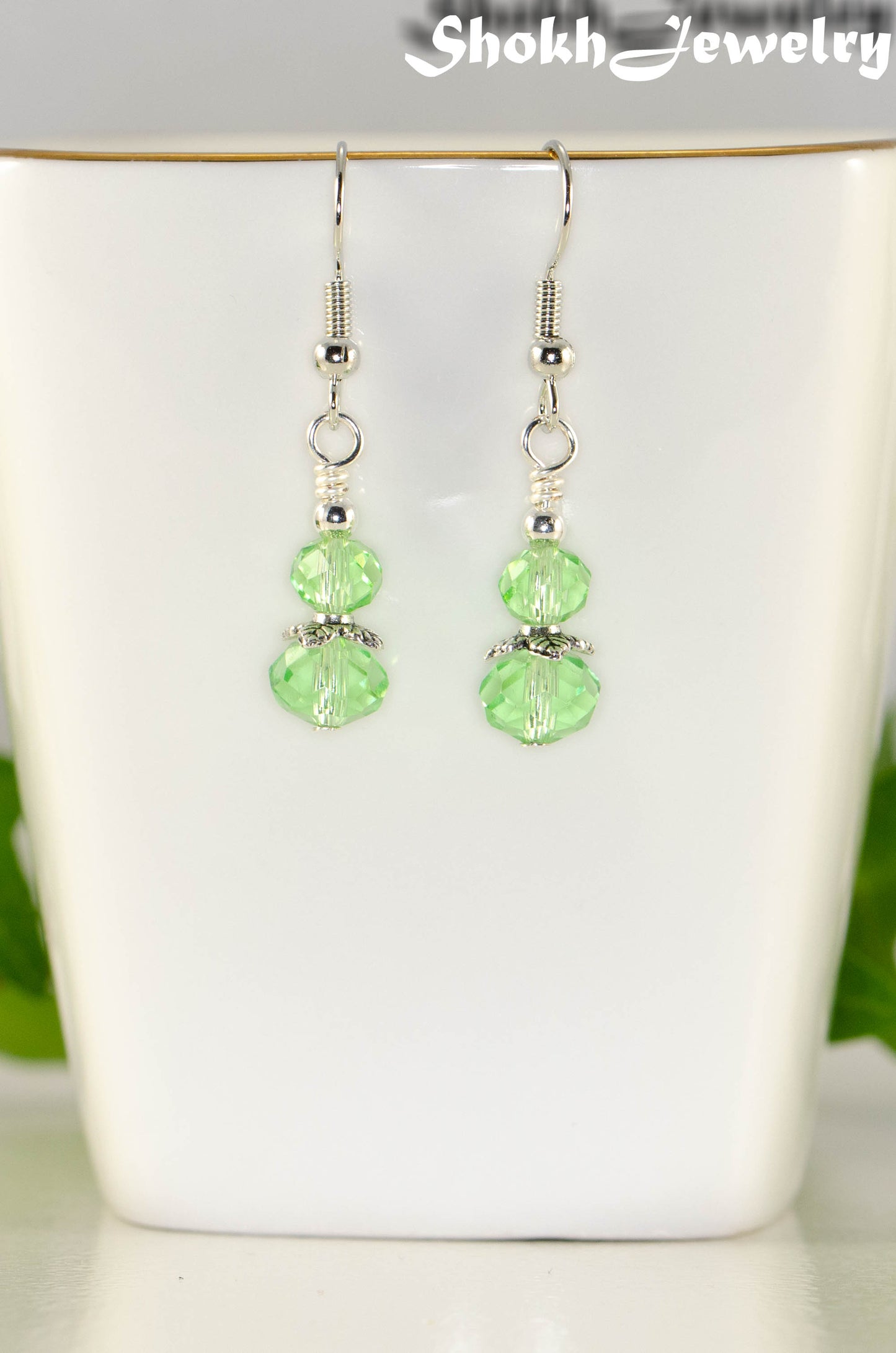 Close up of Small Light Green Glass Bead Dangle Earrings.